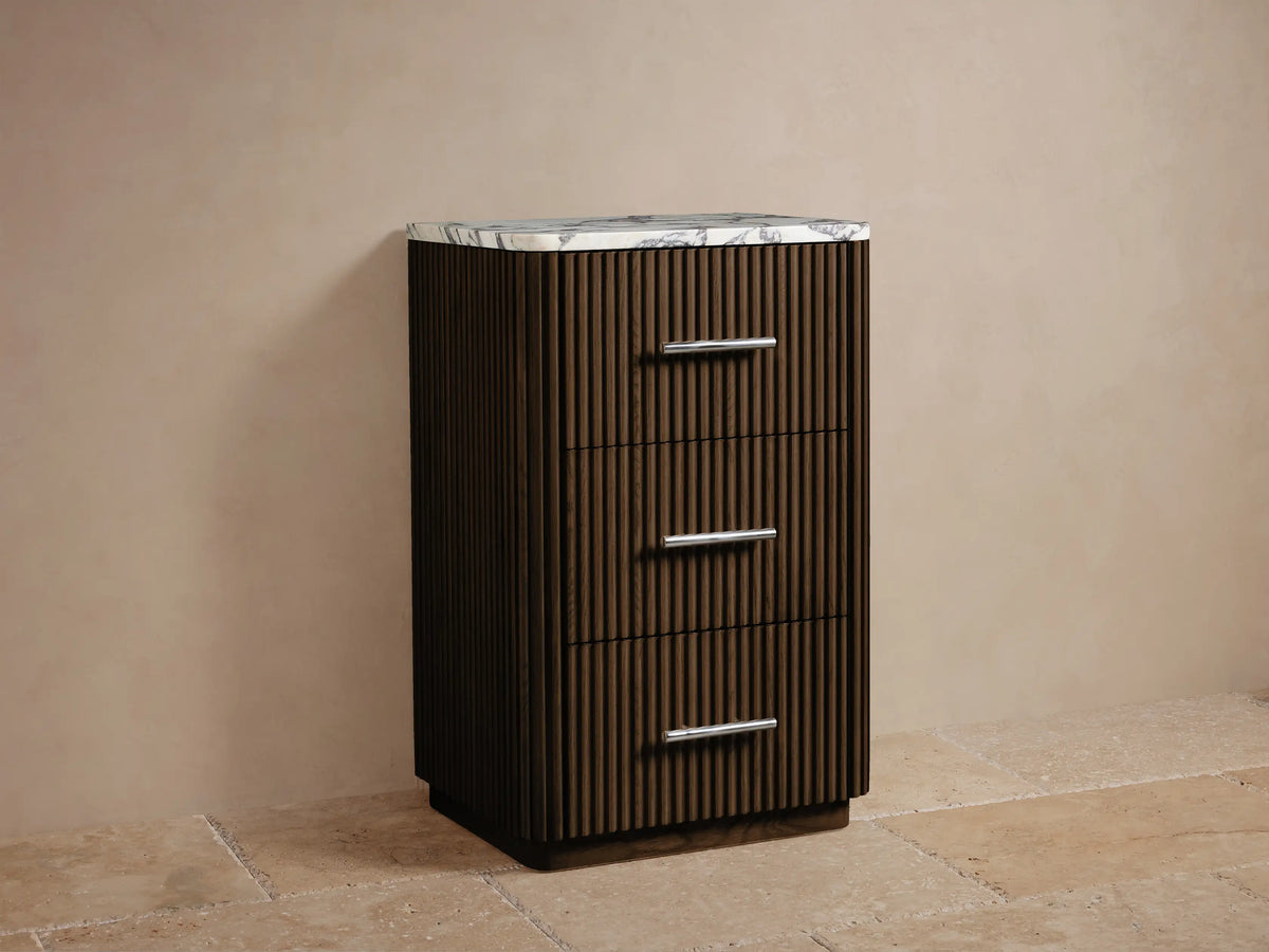 Finnley Short Bath Cabinet, dark brown fluted wood, white marble top with gray veins, 3 drawers with polished nickel handles.