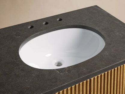 Close-up of Finnley Single Vanity with dark bluestone top, white oval undermount sink, bronze faucet, and reeded oak base.