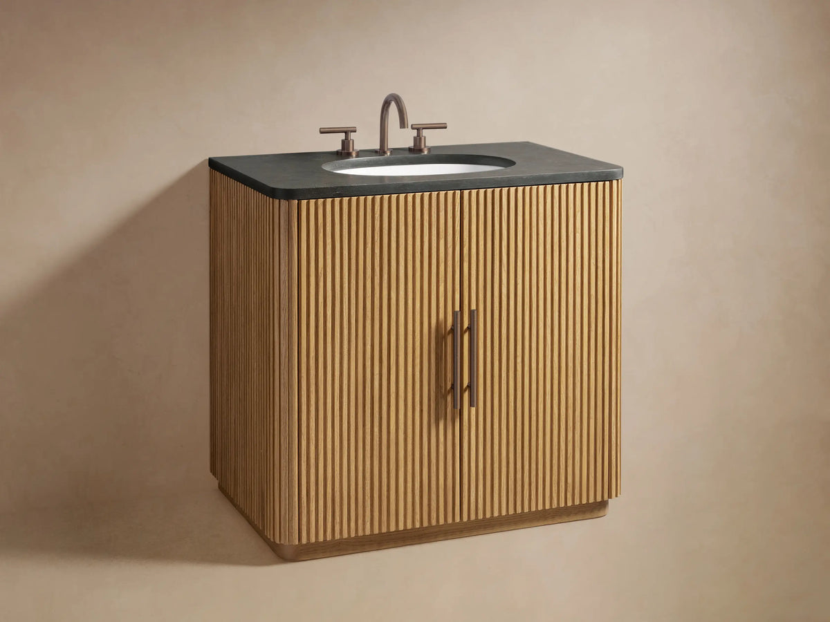Close-up of Finnley Single Vanity's ribbed oak door, partially open, showing an interior shelf with folded beige towels.
