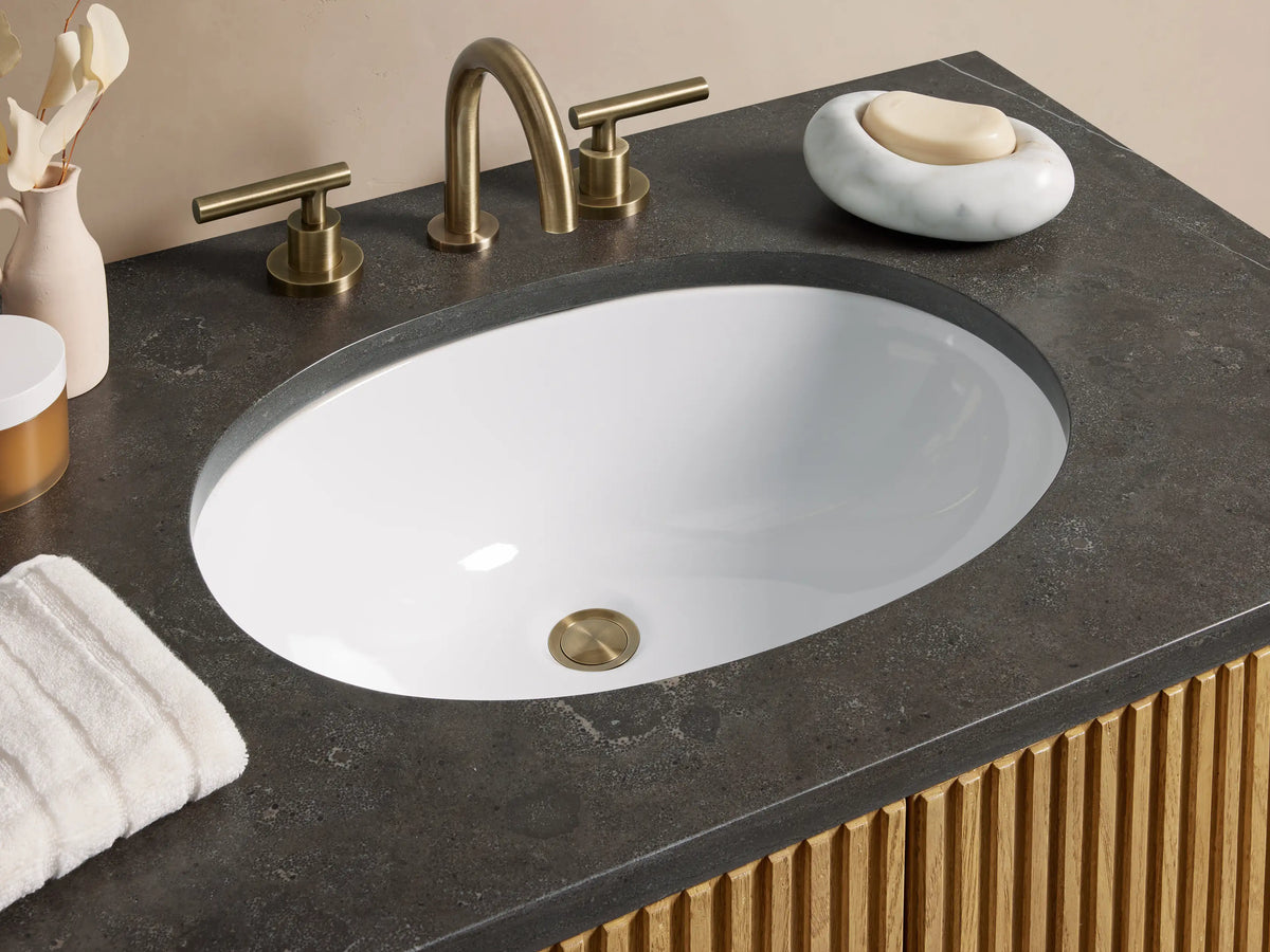 Oak wood Finnley Single Vanity with vertical slat design, black stone top, oval sink, brass faucet, and double brass handles.