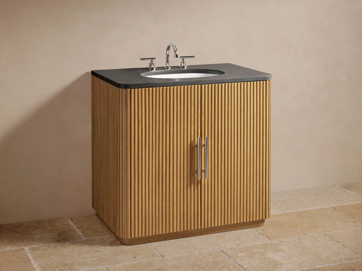 Open oak wood cabinet of the Finnley Single Vanity, revealing a removeable shelf with towels, wooden tray, and brush inside.