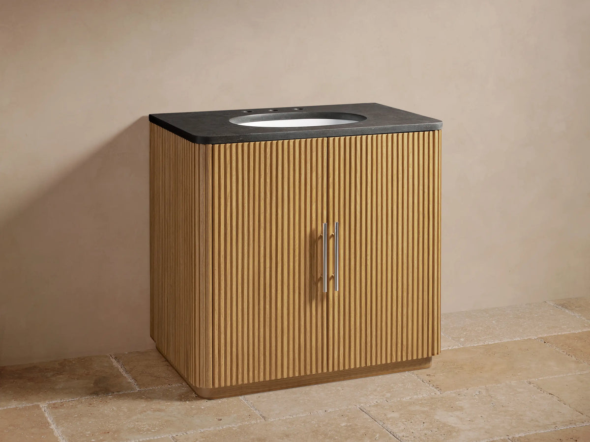 Finnley Single Vanity with oak wood slatted design, bluestone top, and oval sink. Features polished nickel hardware and faucet.