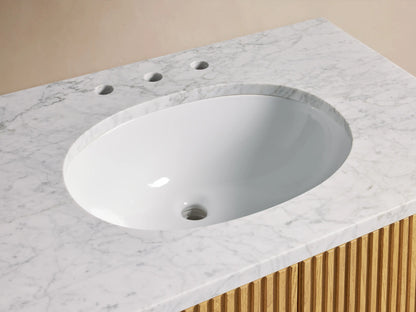 Close-up of Finnley Single Vanity with white oval sink, white Carrara marble top, bronze faucet, and light wood slatted base.