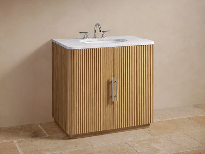 Finnley Single Vanity with ribbed oak wood doors, marble top, and chrome faucet. Features soap dispenser and potted plant.