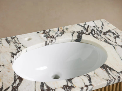 Top-down view of Finnley Single Vanity's white oval undermount sink and white/black/brown veined marble countertop with faucet holes.