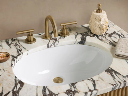 Finnley Single Vanity: Reeded natural oak cabinet with white marble top, brass faucet, and handles, in a neutral bathroom.