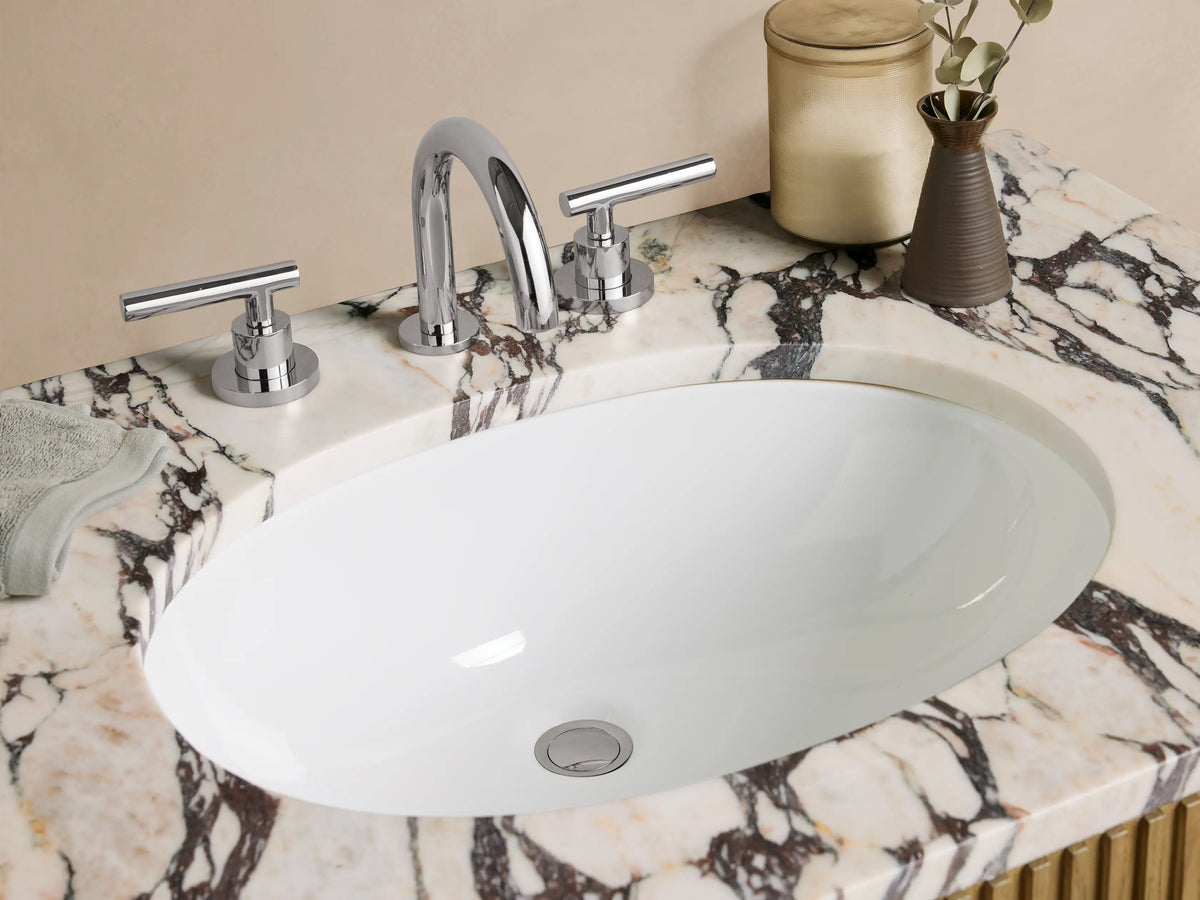 Finnley Single Vanity: Light oak wood cabinet with vertical reeded doors, polished nickel handles, and a white/grey marble top with oval sink.