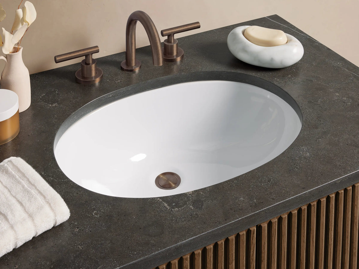 Finnley Single Vanity with dark wood fluted doors, a dark bluestone countertop, and a white oval undermount sink.