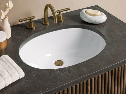 Finnley Single Vanity: front view of dark brown fluted cabinet, dark gray stone top, white oval sink, brass bar handles.