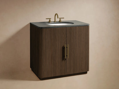 Close-up of the Finnley Single Vanity: dark brown reeded door with a brass handle, partially open, revealing wood shelves with towels and a wooden tray.