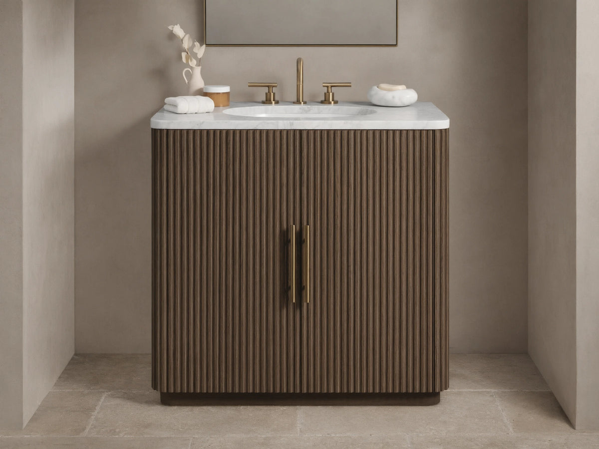 Finnley Single Vanity with dark fluted wood cabinet, white marble top, brass faucet & hardware in a neutral bathroom.
