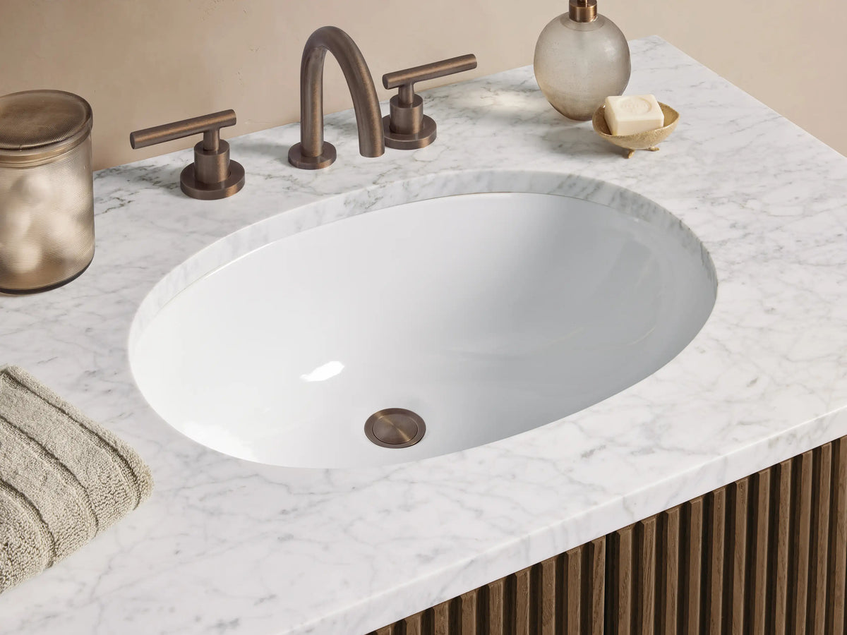 Finnley Single Vanity: Dark brown fluted wood cabinet with white marble top, oval sink, and vertical pulls, on tiled floor.