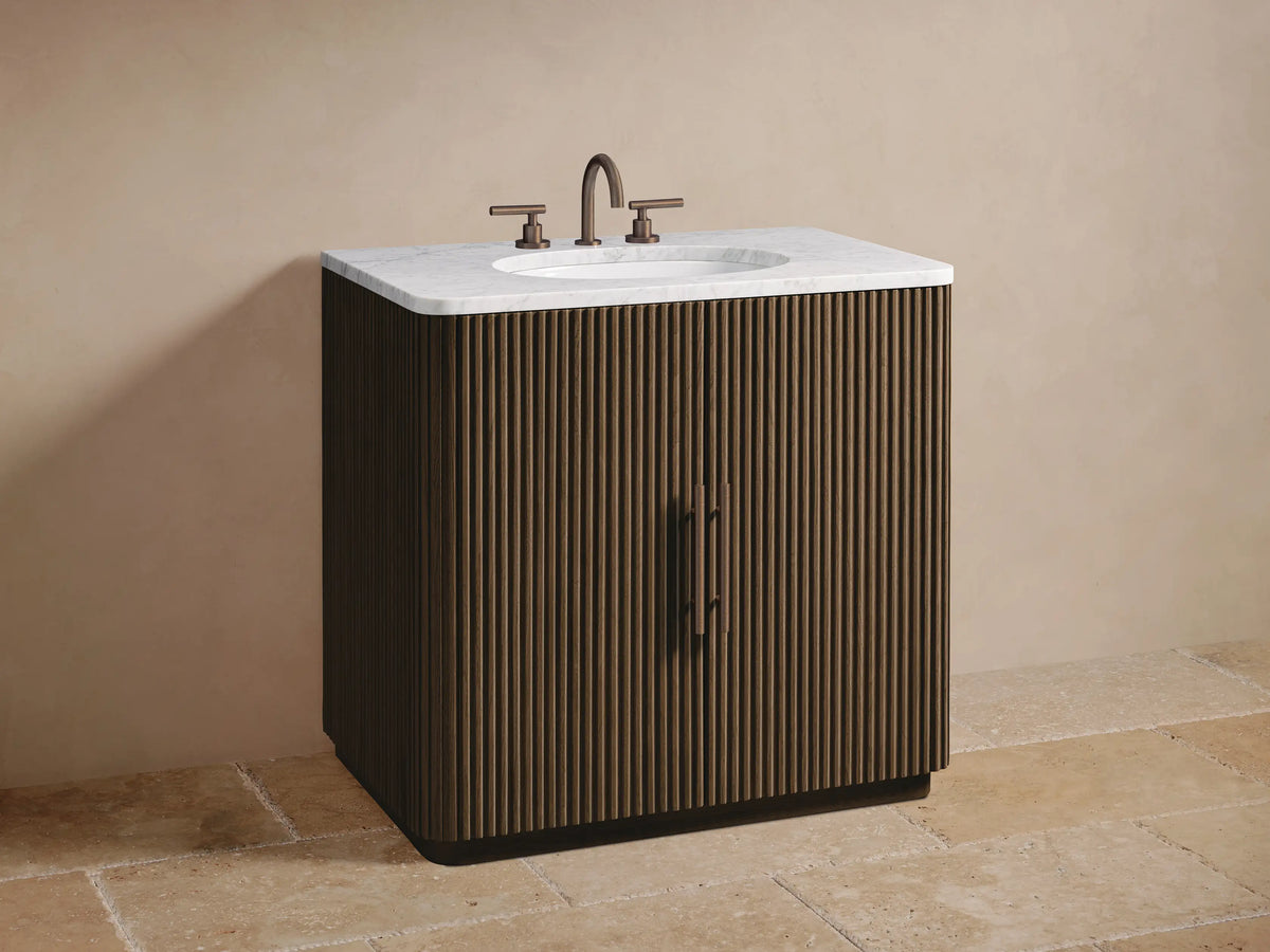 Open ribbed dark oak door of Finnley Single Vanity. Inside, a wooden shelf holds a rustic bowl above neatly stacked light towels.