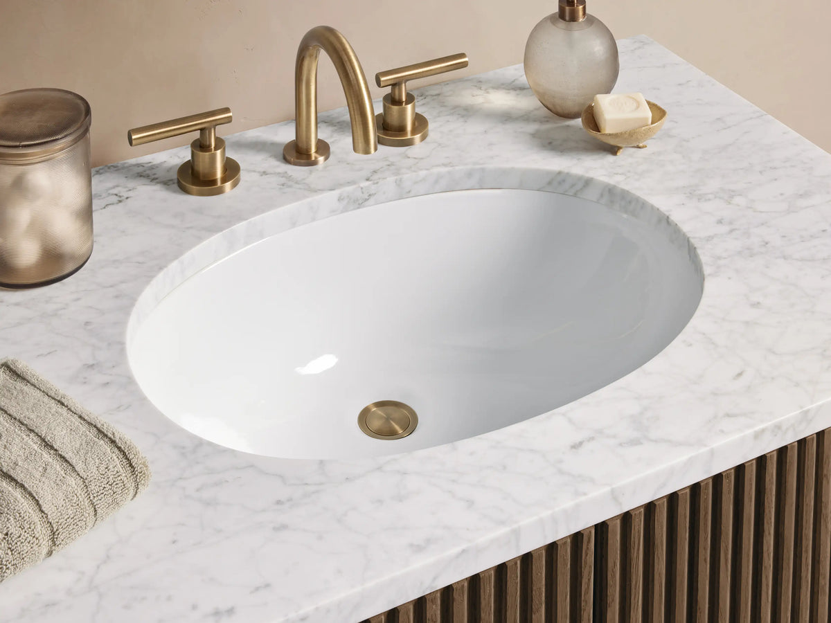 Finnley Single Vanity with dark brown fluted wood cabinet, white marble top, oval sink, and brass pulls in a neutral bathroom.