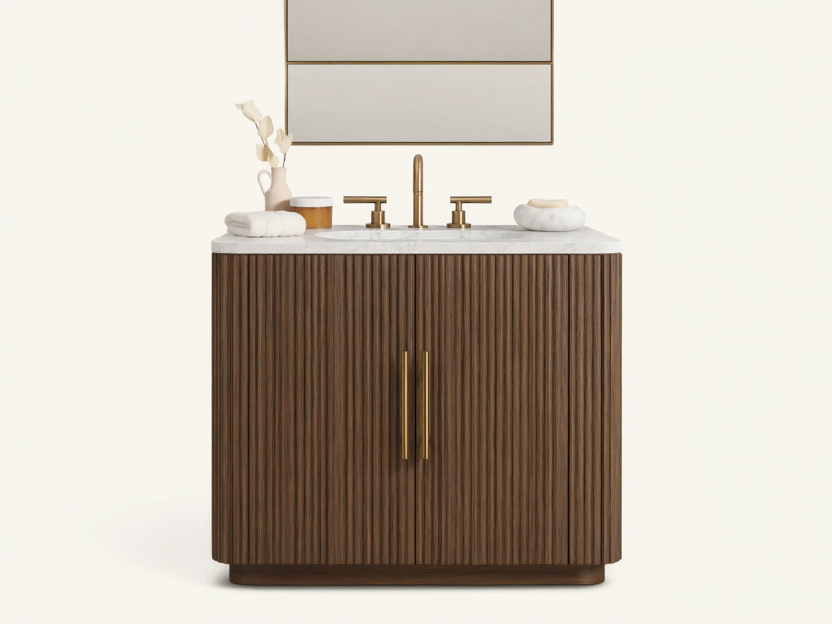 Finnley Single Vanity with dark fluted wood cabinet, white marble top, brass faucet & hardware in a neutral bathroom.