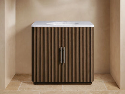 Finnley Single Vanity: Dark fluted wood cabinet with white marble top, chrome faucet, and undermount sink, centered in a bathroom.
