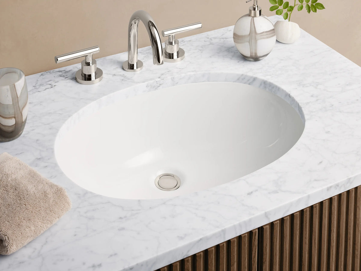 Finnley Single Vanity with white marble top, oval sink, and dark brown fluted cabinet doors with silver handles.