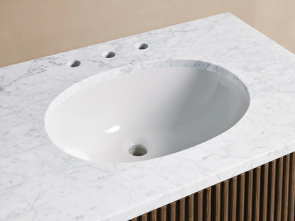 Close-up of Finnley Single Vanity: white oval sink, veined Carrara marble top, chrome faucet, beige towel, soap dispenser.