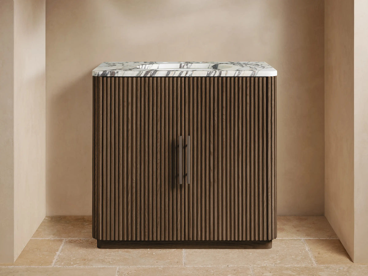 Finnley Single Vanity with dark brown fluted wood cabinet, white marble top, and dark bronze faucet, in a modern bathroom.