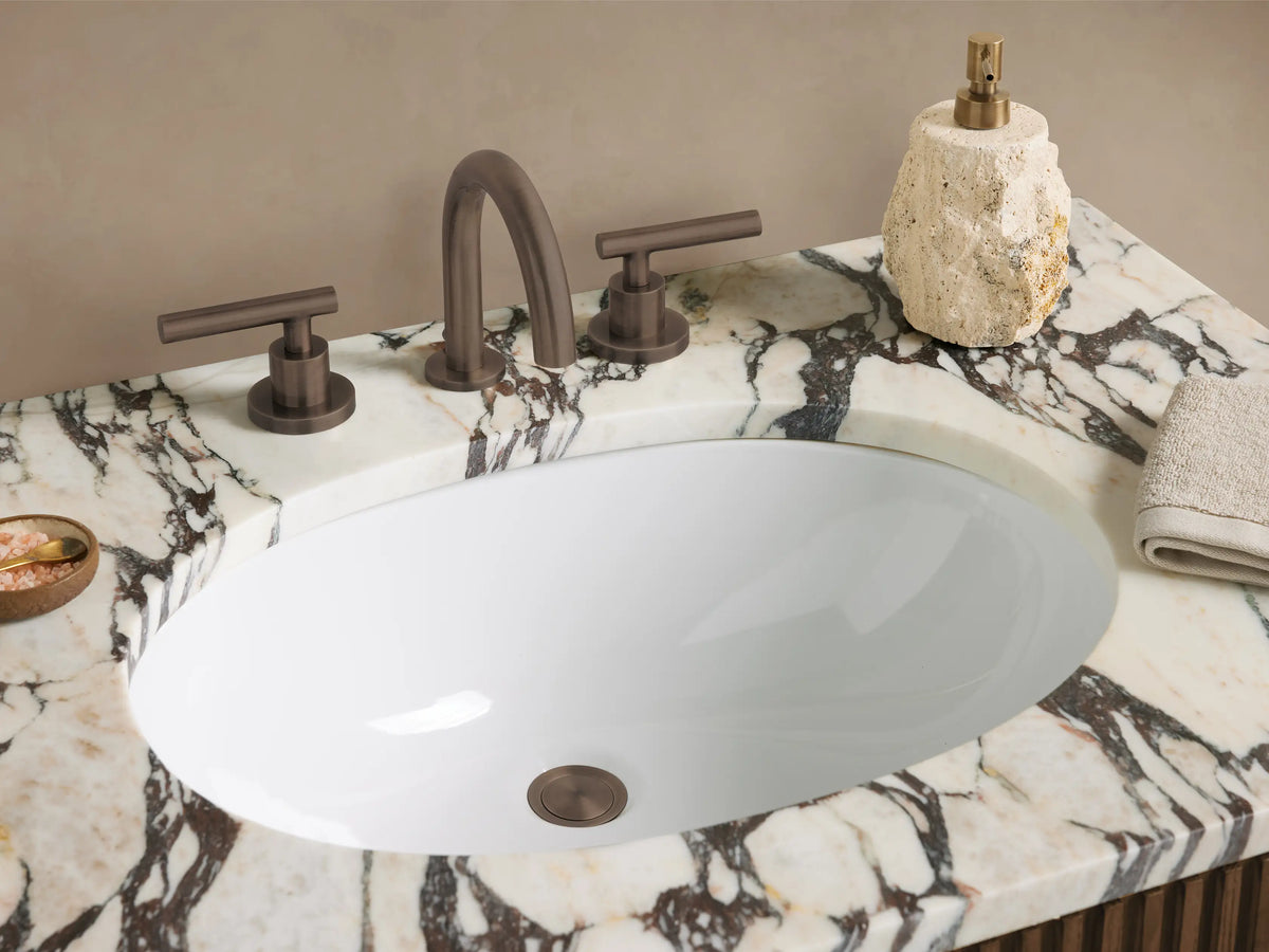 Finnley Single Vanity: Dark brown fluted wood cabinet with grey-veined marble top, oval sink, and bronze bar handles.