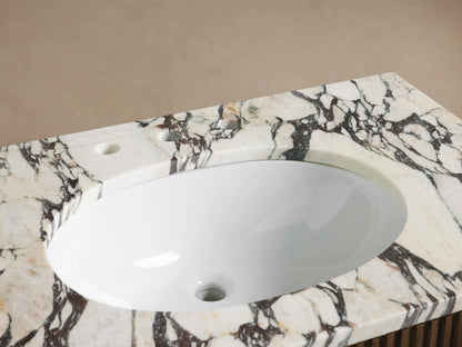 Finnley Single Vanity with oval white sink, dark veined marble countertop, bronze widespread faucet, soap dispenser, towel, bath salts.