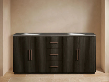 Finnley Wide Vanity: Dark brown fluted double vanity with gray stone top, 2 white sinks, bronze faucets. Left door open, towels visible.