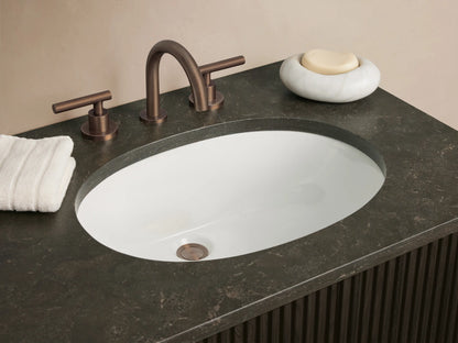 Dark brown fluted Finnley Wide Vanity with a dark stone top, two white undermount sinks, and bronze handles.