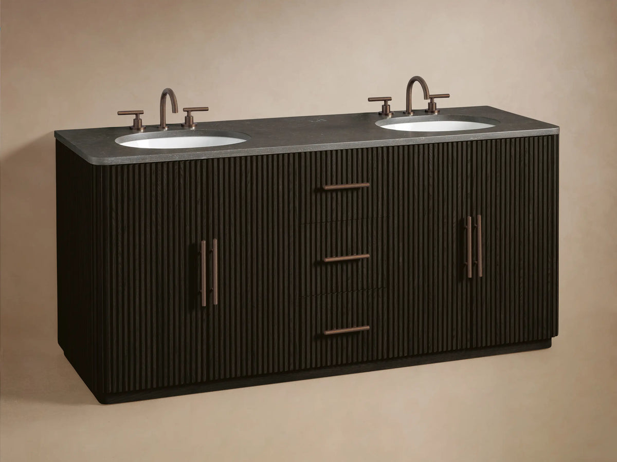 Dark fluted wood Finnley Wide Single Vanity with partially open drawer revealing neatly folded beige towels. Bronze hardware.