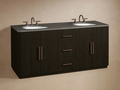 Dark fluted wood Finnley Wide Single Vanity with partially open drawer revealing neatly folded beige towels. Bronze hardware.