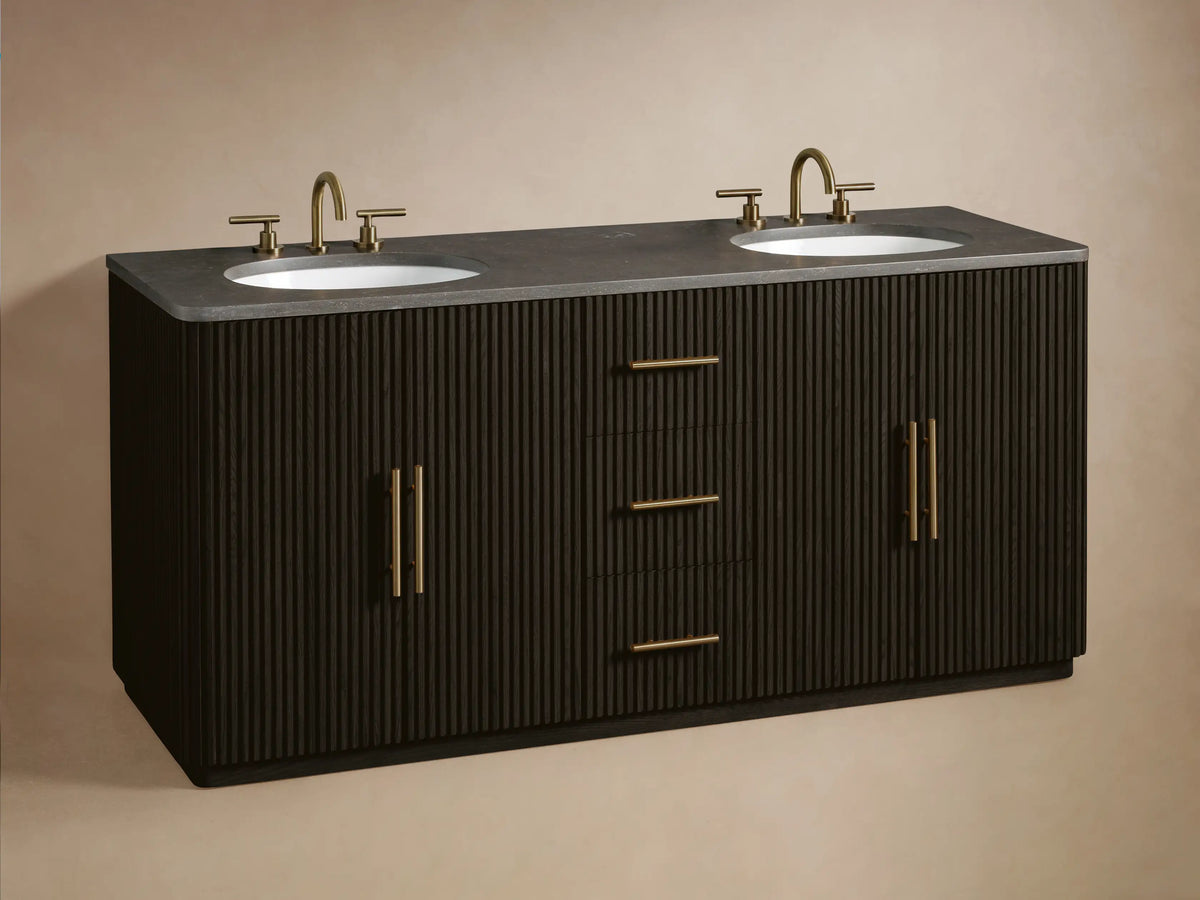 Close-up of Finnley Wide Single Vanity. Dark ribbed wood with golden handles. One drawer partially open revealing beige towels.