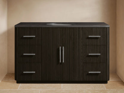 Dark brown fluted Finnley Wide Single Vanity with dark stone top, oval sink, chrome faucet, 2 left drawers, 3 right drawers, 2 center doors with chrome pulls.