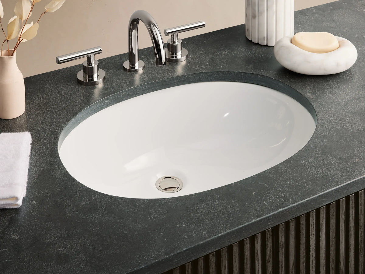 Finnley Wide Single Vanity: Dark espresso fluted cabinet, dark bluestone top with oval sink, and polished nickel hardware.