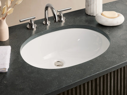 Finnley Wide Single Vanity: Dark espresso fluted cabinet, dark bluestone top with oval sink, and polished nickel hardware.