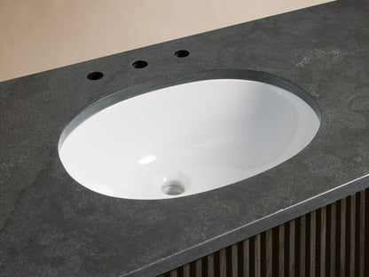 Finnley Wide Single Vanity close-up. Dark gray honed stone countertop, white oval undermount sink, chrome faucet.