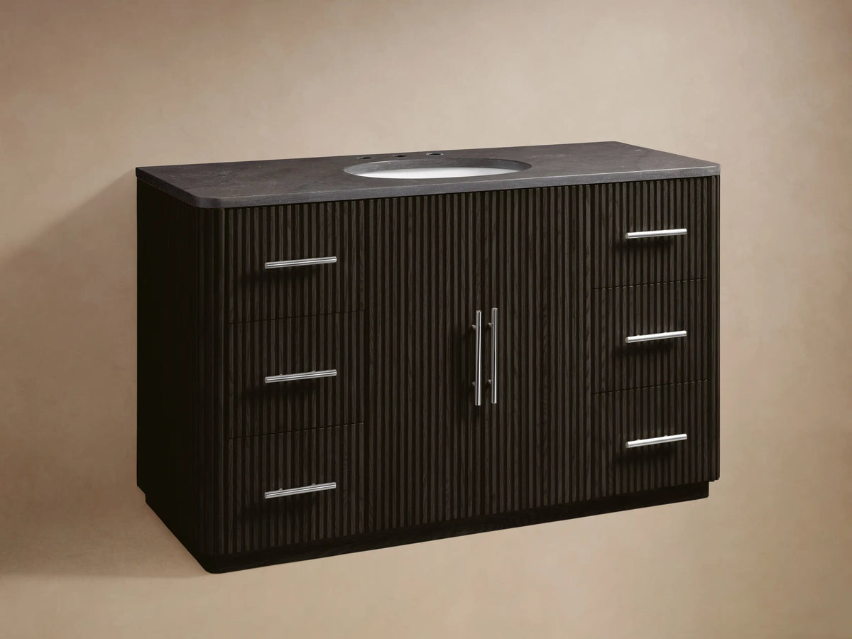 Dark fluted Finnley Wide Single Vanity with bluestone top, oval ceramic sink, chrome faucet, & polished nickel hardware.
