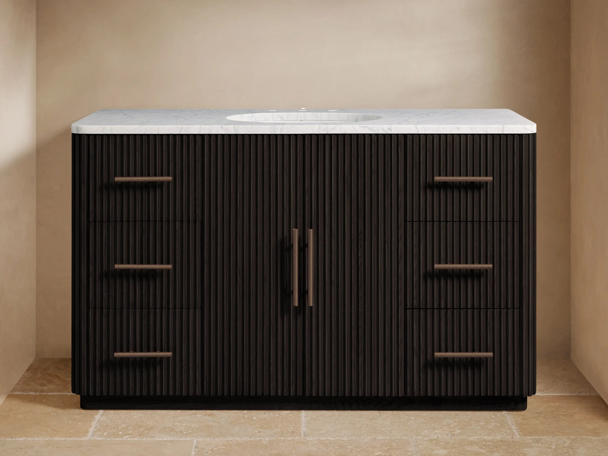 Dark ribbed wood Finnley Wide Single Vanity with white marble top, single sink, bronze faucet, 6 drawers, and 2 central doors.