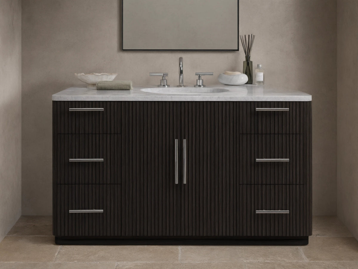 The image shows the Finnley Single Wide Vanity with a dark oak finish. It has a white stone top and an oval ceramic sink, with silver hardware on six drawers and two central doors.