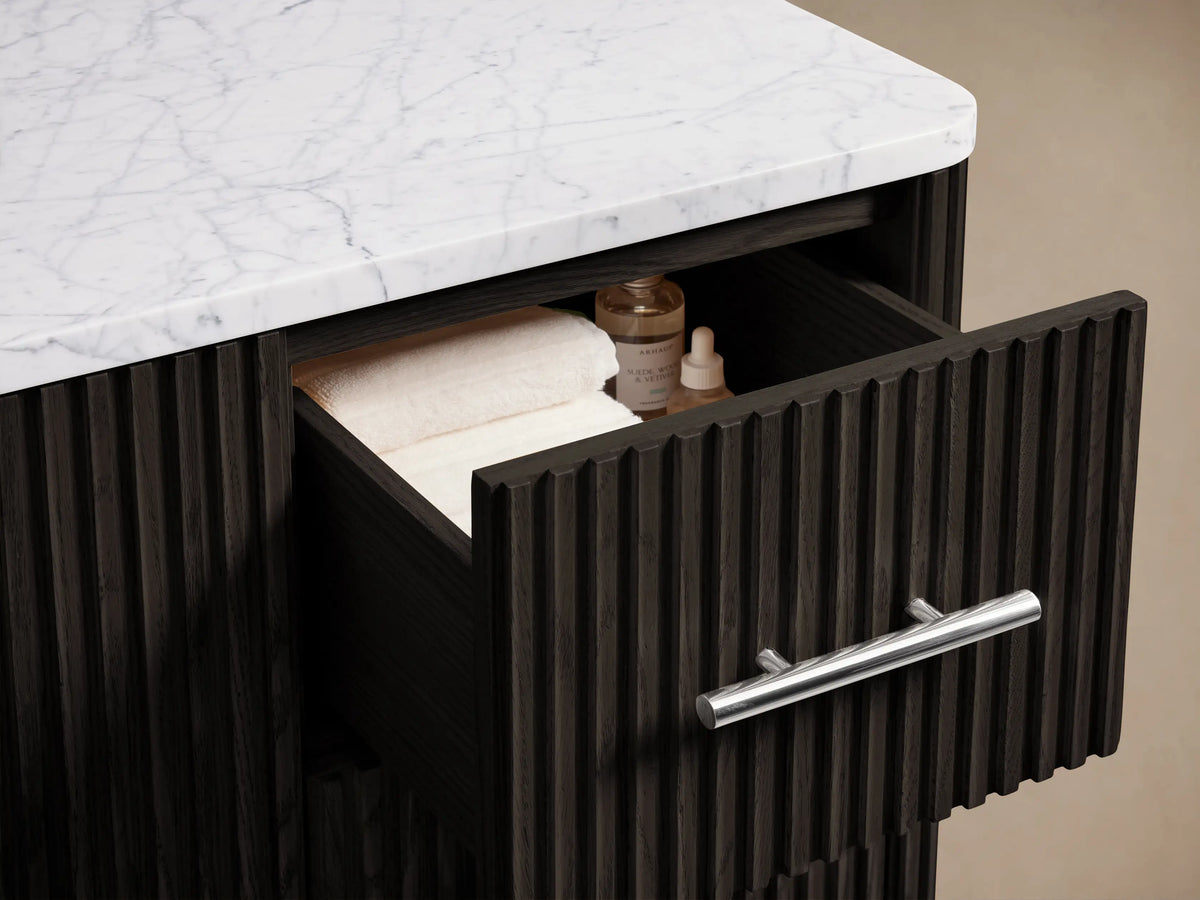 Finnley Single Wide Vanity in dark brown oak with vertical grooves, featuring sleek polished nickel handles. Cabinet door is open, revealing shelves.