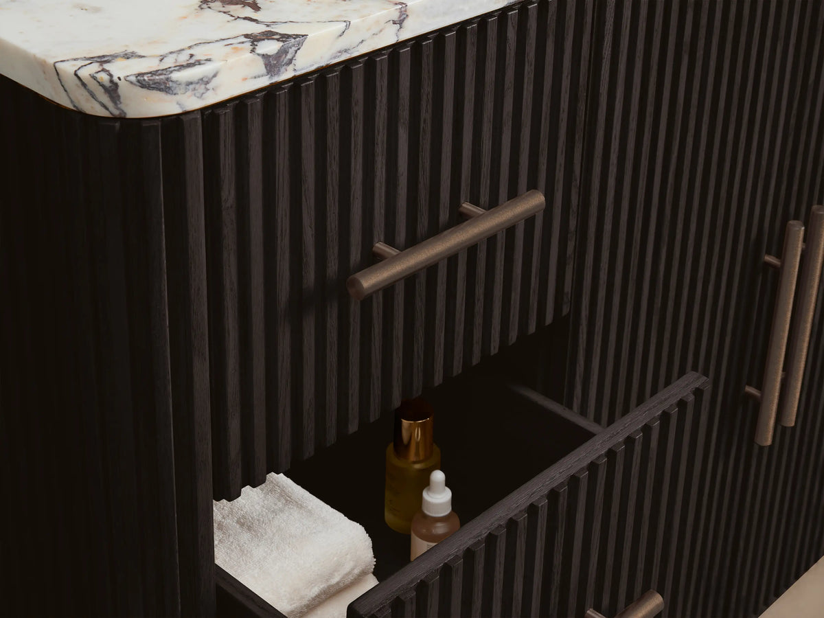 Close-up, top-down view of Finnley Wide Single Vanity. White marble top with prominent reddish-brown veining, oval white sink, 3 faucet holes.