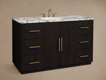 Finnley Wide Single Vanity: dark fluted cabinet, brass handles, white marble top with reddish veining, oval sink.