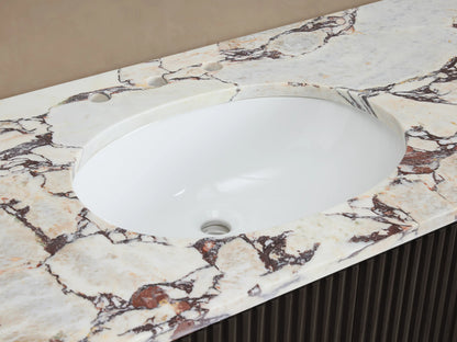 Finnley Wide Single Vanity: White oval sink, brass faucet, Calacatta Viola marble top, with a dark, ribbed base.