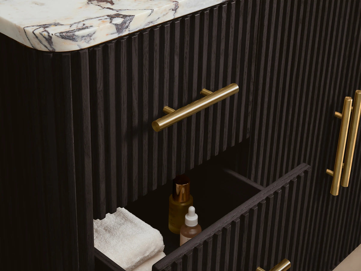 Close-up of Finnley Wide Single Vanity's dark brown fluted wood door, partially open, with a gold handle, revealing white towels.