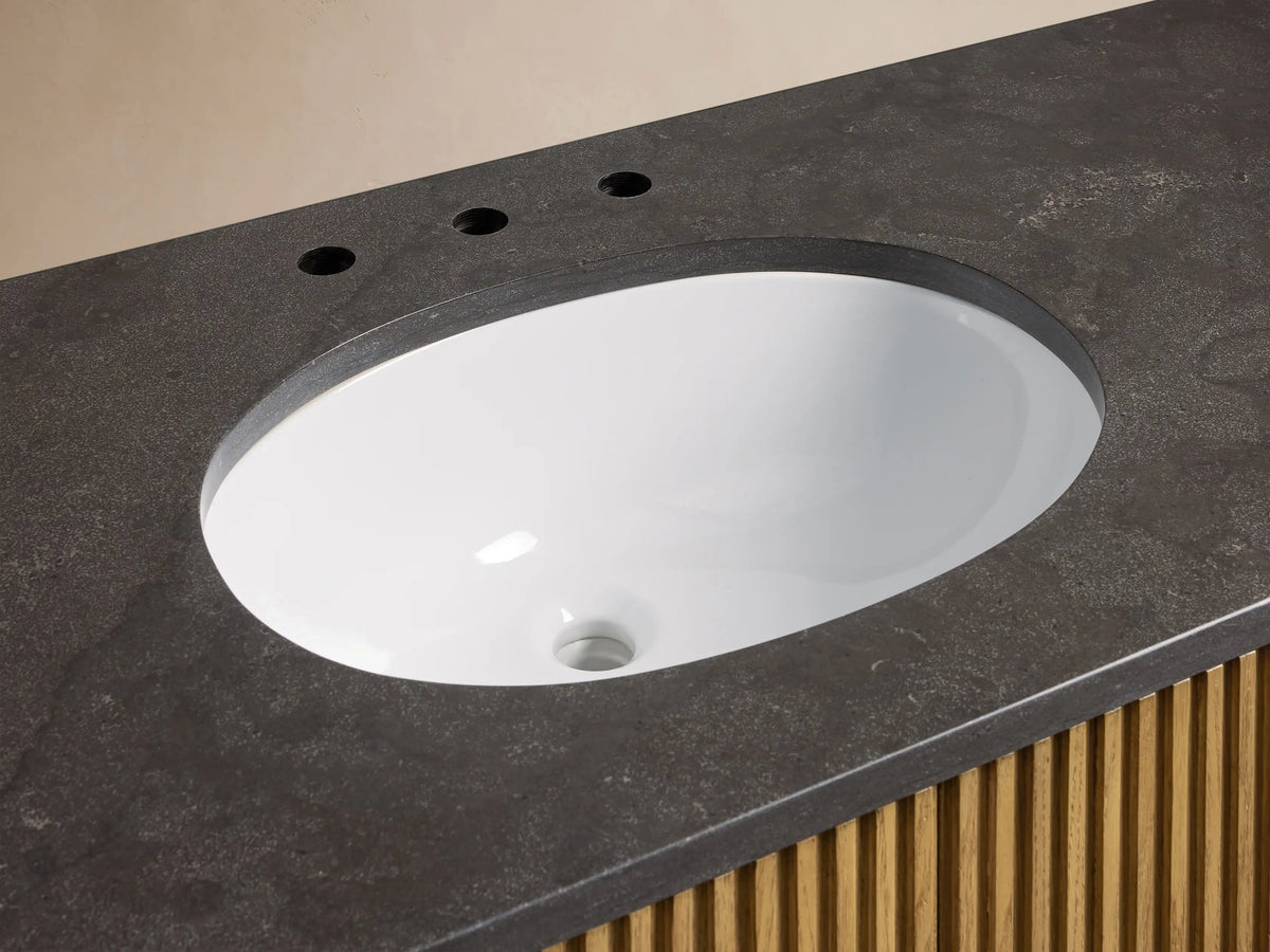 Close-up of Finnley Wide Single Vanity featuring dark stone countertop, oval white ceramic sink, bronze faucet, and slatted wood base.