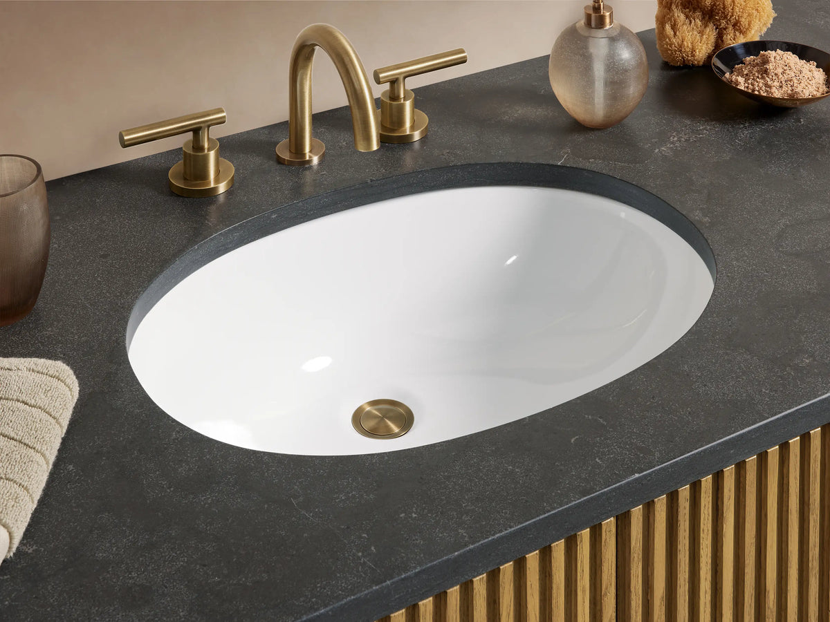 Finnley Single Wide Vanity in oak with vertical lines, six drawers, center doors, black stone top, and brass handles.