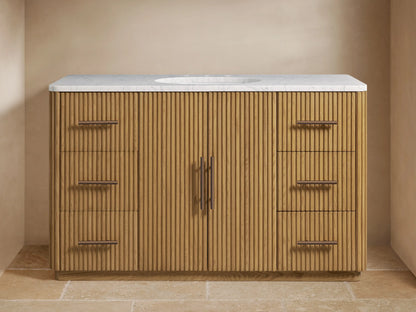 Finnley Wide Single Vanity with ribbed oak wood cabinet, white marble top, oval sink, and Antique Bronze hardware.
