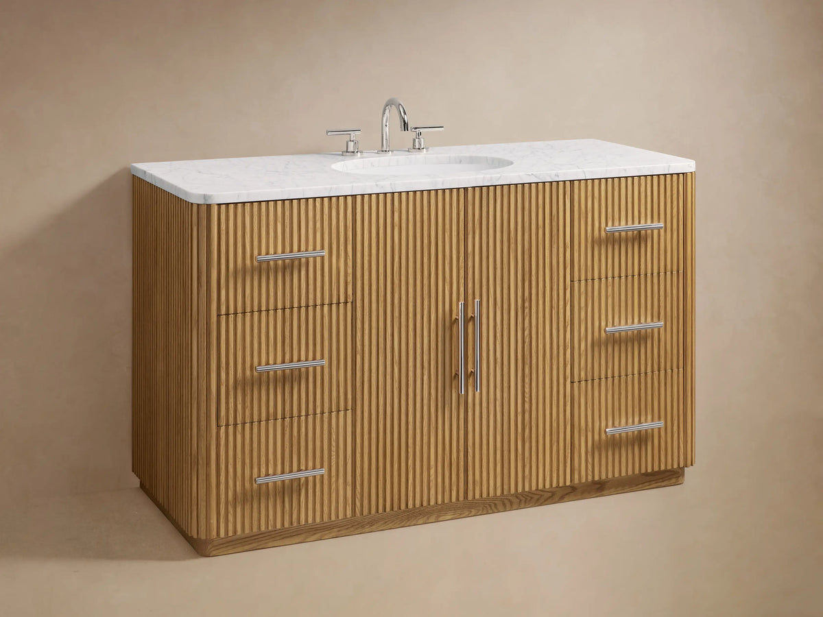 Finnley Single Wide Vanity with natural oak finish, featuring vertical ridges, metallic handles, open cabinet with linens inside.