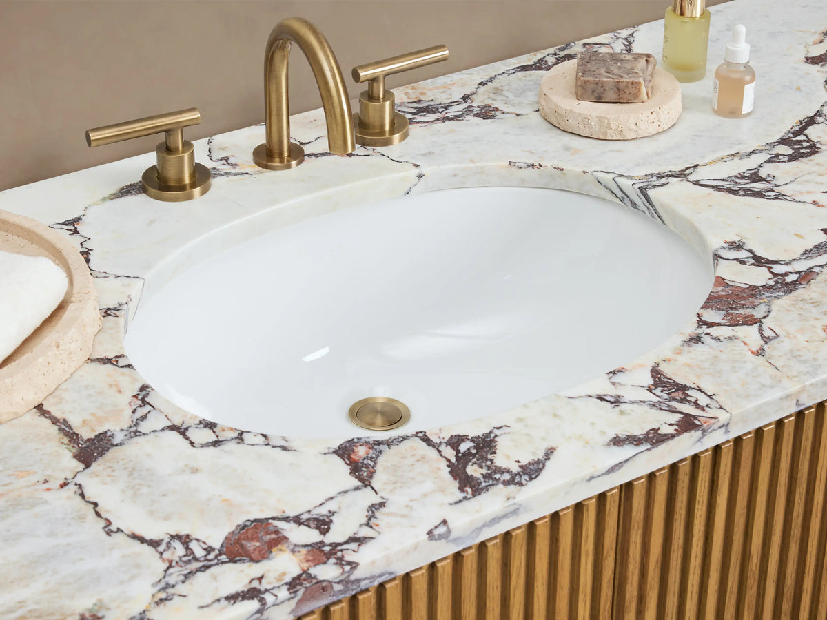 Finnley Wide Single Vanity: Light oak wood with vertical fluting, white marble top with gray veining, and brass bar pulls.