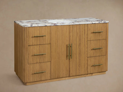Finnley Wide Single Vanity: light oak wood with ribbed texture, white marble top, oval sink, brass faucet, and six drawers.