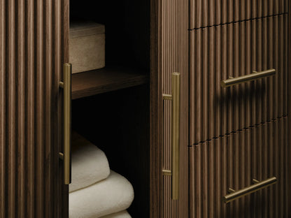 Finnley Wide Single Vanity with dark stone top, fluted dark wood, and an open drawer holding white towels, brass handle.
