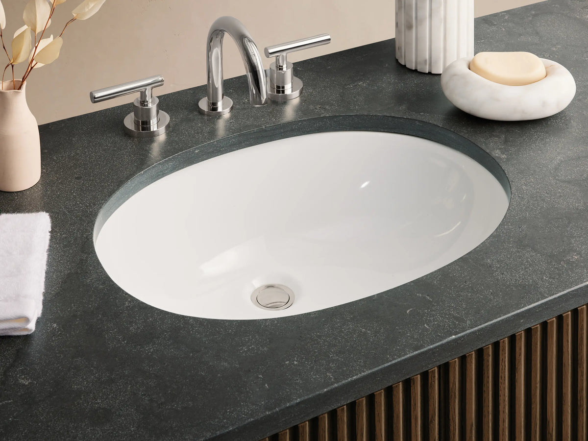 Finnley Wide Single Vanity with fluted dark brown wood cabinet, dark stone top with sink, and polished nickel hardware, front view.